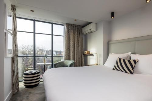 阿姆斯特丹Maison ELLE Amsterdam的一间卧室设有一张大床和一个大窗户
