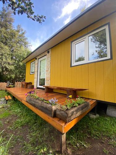 圣卡洛斯-德巴里洛切Amapola Tiny House的黄色的小房子,设有木甲板