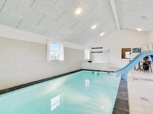 博托比24 person holiday home in Idestrup的白色墙壁的房间内的游泳池,带滑梯