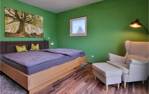 兰格劳3 Bedroom Cozy Home In Langlau的绿色卧室配有床和椅子