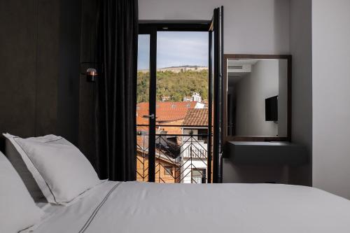 普里兹伦Triumf Hotel的一间卧室设有一张床和一个美景窗户。