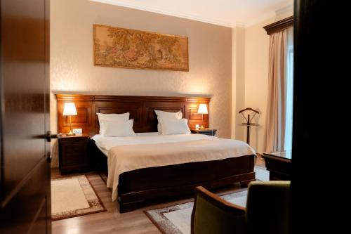 拉姆尼库沃尔恰索菲亚努大酒店的卧室配有一张带白色床单和枕头的大床。