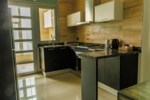 雷孔基斯塔ALTA VISTA APART HOTEL的厨房配有黑色柜台和白色橱柜