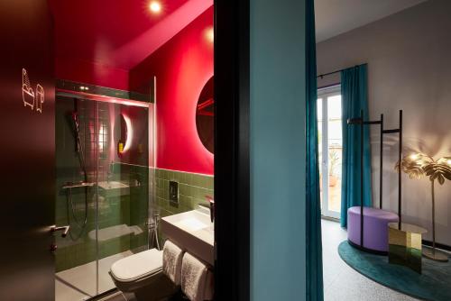 罗马JO&JOE ROMA的一间带卫生间、水槽和红色墙壁的浴室