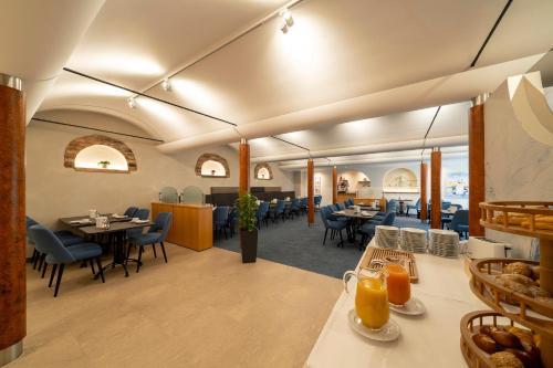 莱茵河畔凯尔Hotel Schwanen的一间在房间内配有桌椅的餐厅