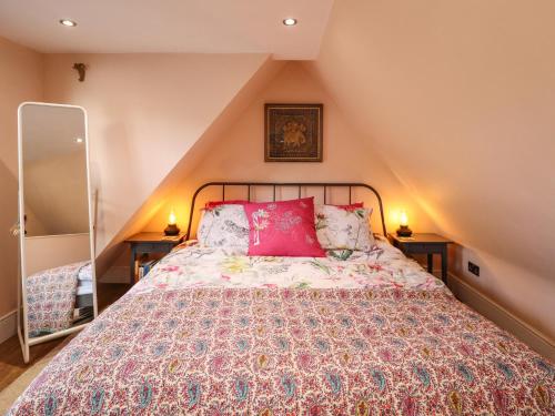 根斯堡The Granary Owl House的一间卧室配有一张带红色枕头的大床