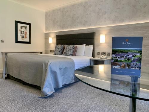 多尼戈尔米尔公园酒店的酒店客房设有一张大床和一张玻璃桌