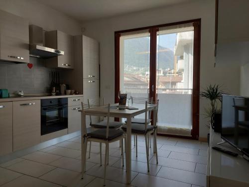 松德里奥Bilocale luminoso, ottima posizione, wi-fi e sky的厨房配有桌椅和窗户。