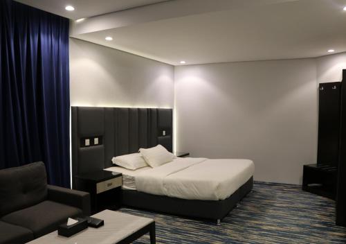 艾卜哈قمم بارك Qimam Park Hotel 1的配有一张床和一把椅子的酒店客房