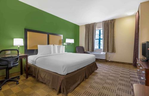 斯普林代尔Extended Stay America Select Suites - Fayetteville - Springdale的酒店客房设有一张大床和一张书桌。