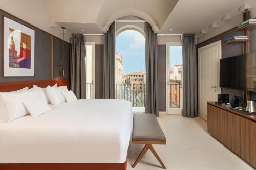 博洛尼亚Hotel Brun的卧室设有一张白色大床和大窗户