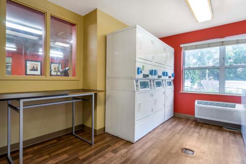 Murphys Corner西雅图 - 埃弗雷特 - 银湖美国长住酒店的厨房配有白色冰箱和红色墙壁