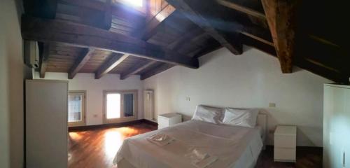 博洛尼亚De' Pepoli Rooms & Apartments的卧室设有白色的床和木制天花板。