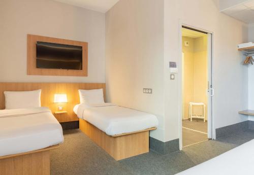 里摩日B&B HOTEL Limoges Centre Gare的一间酒店客房,设有两张床和电视