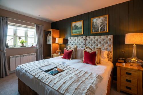 奇平索德伯里多尔当皇冠酒店的一间卧室配有一张带红色枕头的大床