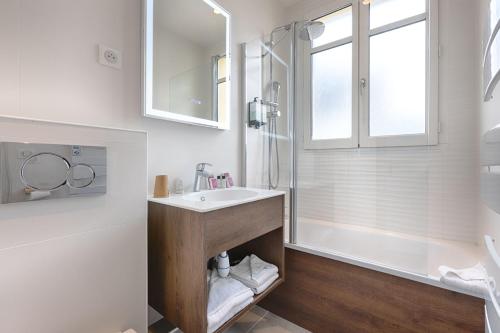 巴黎法兰西因瓦里德酒店的白色的浴室设有水槽和淋浴。