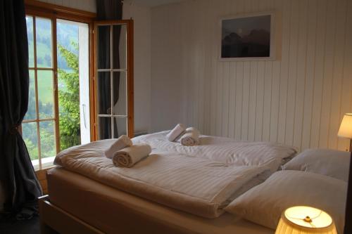 MolesonLe Loup, grand chalet coup de cœur的床上的床铺,上面有毛巾,还有窗户