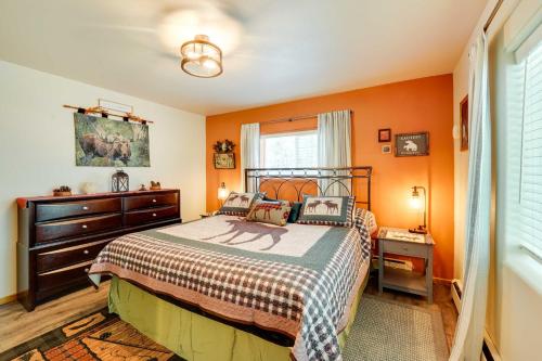 索尔多特纳Single-Story Soldotna Home Near the Kenai River!的一间卧室拥有橙色的墙壁,配有一张床和一个梳妆台