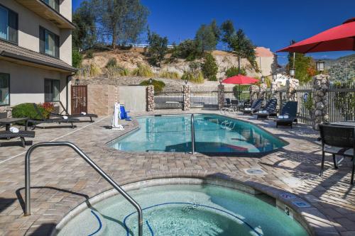 奥克赫斯特优胜美地南门套房酒店的一座带椅子的庭院和一座建筑中的游泳池