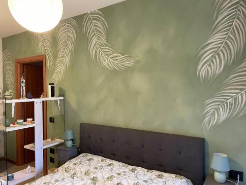 佩罗“The green house” Fiera Milano的一间卧室配有一张带绿叶墙的床