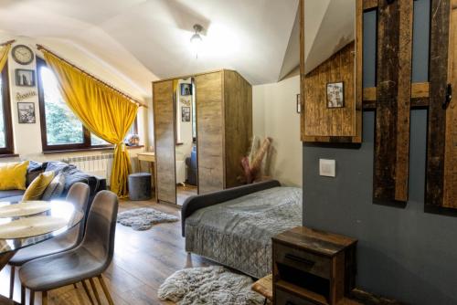 波罗维茨Borovets Dream Studio的一间卧室配有一张床、一张沙发和一张桌子