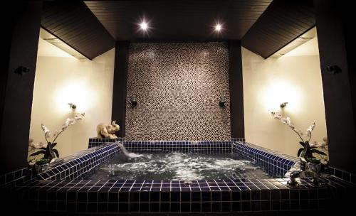 奈汉海滩4号酒店的一个带按摩浴缸的瓷砖墙客房
