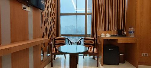 达卡Hotel Royal Bengal的窗户客房内的桌椅
