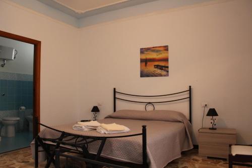 阿尔盖罗Alghero Budget Automated check in的一间卧室配有一张床、一张桌子和一张图片