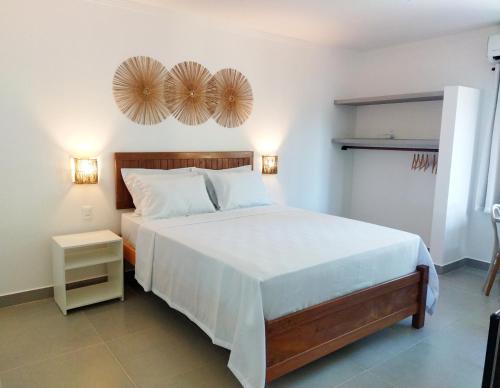 雅帕拉廷加Pousada Fenícia的卧室配有一张大床,墙上挂有2个风扇
