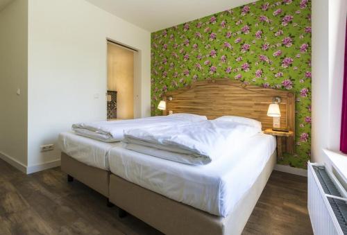 伯格恩特尔布里特Herberg de Geulhemermolen的一间卧室设有一张带花卉墙壁的大床