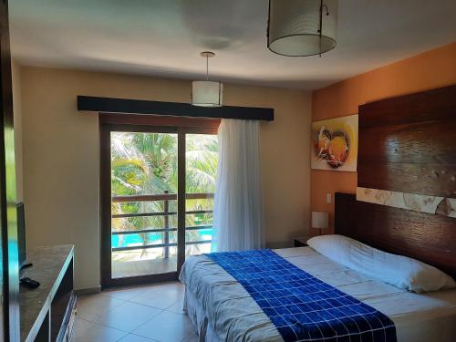 尼西亚弗洛雷斯塔Apartamento 320 Praia Bonita Resort的一间卧室设有一张床和一个大窗户