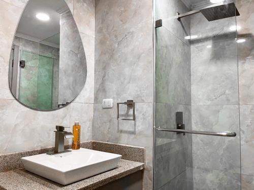 瓜亚基尔Depa de lujo con piscina y jacuzzi的浴室配有盥洗盆和带镜子的淋浴