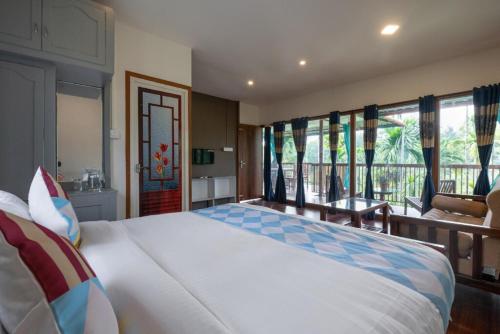 PanamaramGreens Vista Wayanad - Premium Homestay Near Natural Stream的一间带大床的卧室和一个阳台