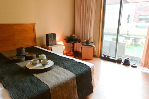 济州市大同酒店的一间卧室配有一张带蜡烛的桌子的床。