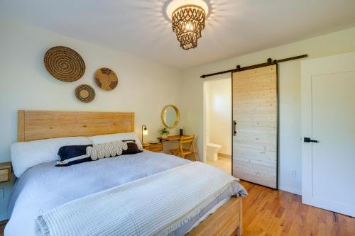 滨海城Seaside Home with Hot Tub and Patio Close to Beaches!的一间卧室配有一张大床和一个吊灯。