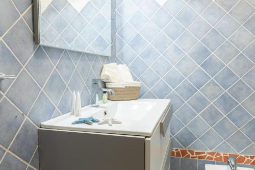 利斯西亚迪维卡Nuovi Appartamenti Tri e Bilocali in Residence con Piscina a Porto Cervo 800mt Mare的一间带水槽和镜子的浴室
