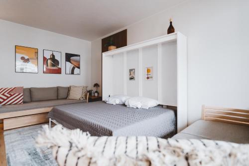 赫尔辛基Scandic Primo Apartments - Design District 69m2的一间卧室配有一张床和一张沙发