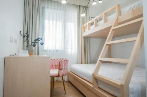 大雅台Elegant, and Family-Friendly 2BR in Pine Suites的一间卧室配有双层床和书桌