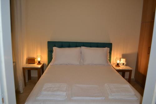 GraviáGravia's Villa的一间卧室配有一张床,两台桌子上放着两盏灯