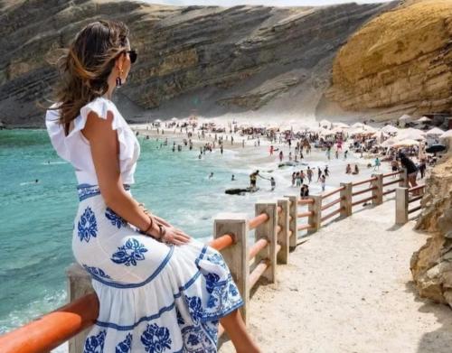 伊察Hotel Kallma Adventures的坐在海滩围栏上的孕妇