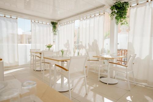 圣克鲁斯-德特内里费Emblemático F24-Only Adults B&B的一间设有白色椅子和桌子的用餐室以及窗户。