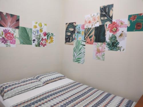 特林达德Ti Hostel Trindade Hospeda的卧室的墙上装饰有四幅画作