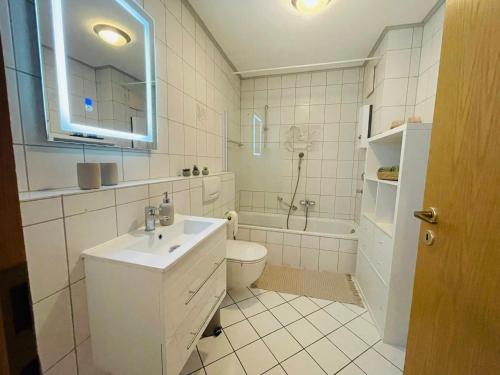 海格尔Stilvolles 4-Bett Appartment的浴室配有盥洗盆、卫生间和浴缸。