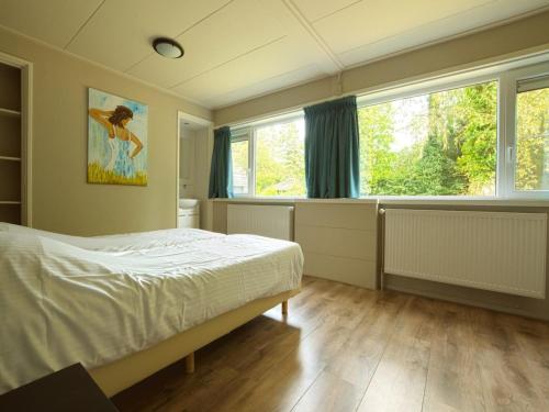 洛赫姆Beautiful holiday home in Lochem with garden的一间卧室设有一张床和一个大窗户