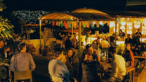 瓦哈卡市Viajero Oaxaca Hostel的一群人晚上坐在酒吧里