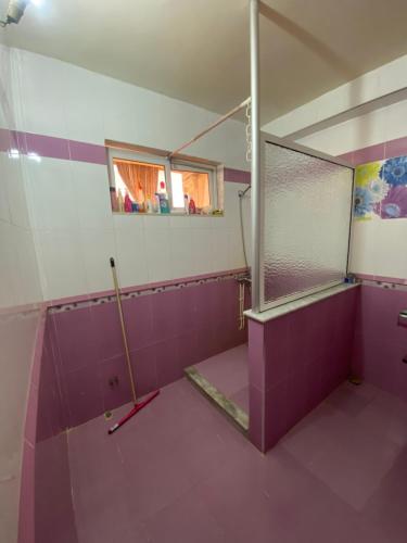 特莱姆森Appartement haut standing的一间铺有紫色瓷砖并配有蚊帐的小浴室