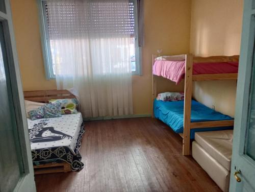 GualeguaychúChandra Alojamiento en casa de familia的客房设有两张双层床和一扇窗户。