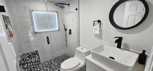 塔马拉克Private Cozy & Spacious Room at a house with pool的一间带卫生间、水槽和镜子的浴室