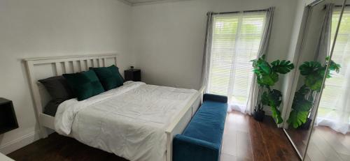 塔马拉克Private Cozy & Spacious Room at a house with pool的一间卧室配有一张带绿色枕头的床