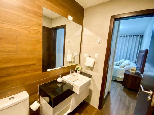 圣克鲁斯Departamento Elegante y Relax by Torre Vento的一间带水槽和镜子的浴室以及一张床